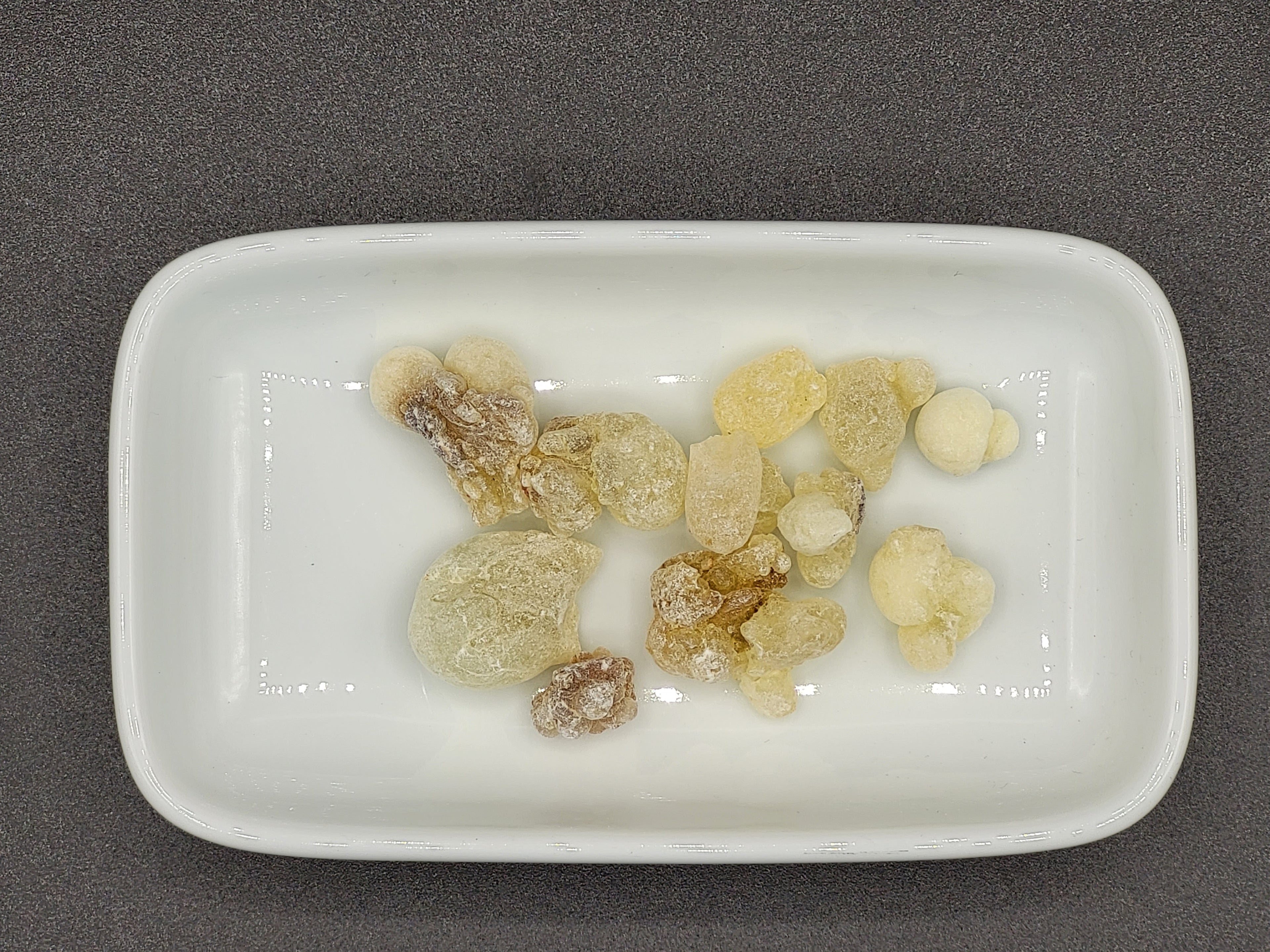 Räucherharz in kleinen Stücken auf weißer Schale, natürlicher Bestandteil einer Räuchermischung