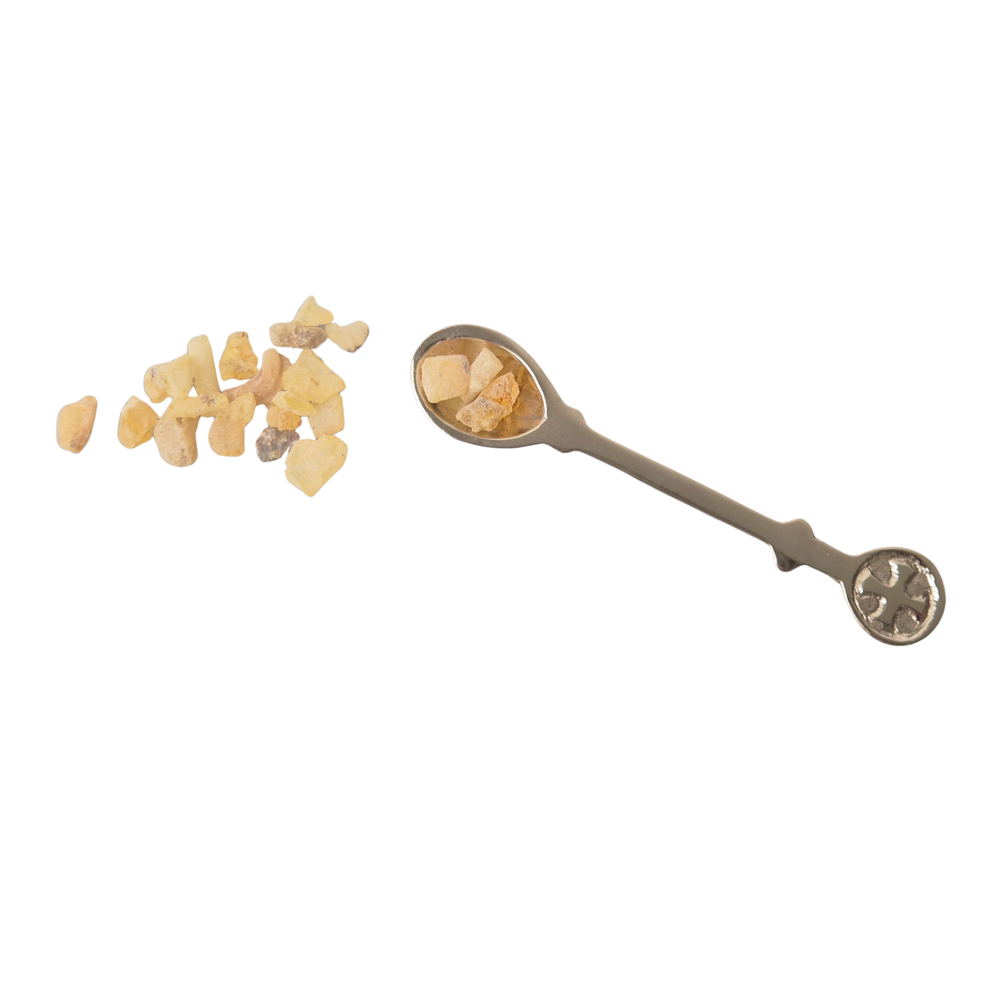 Löffel mit Weihrauch: Weihrauchlöffel aus vernickeltem Messing mit Weihrauchstücken in der Löffelschale und daneben auf weißem Hintergrund.